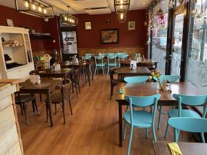 a restaurant with wooden tables and blue chairs at Restaurant Hostel Aan Tafel in Lunteren