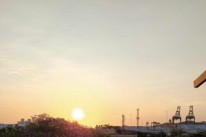 una puesta de sol sobre una ciudad con grullas en red moon, en Santa Marta