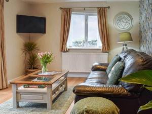 uma sala de estar com um sofá de couro e uma mesa de centro em Cremlyn Lodge em Beaumaris