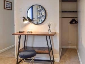 una scrivania con specchio e sedia in camera di Cremlyn Lodge a Beaumaris