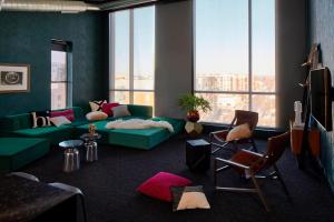 a living room with a green couch and a large window at MOXY Minneapolis Uptown in Minneapolis