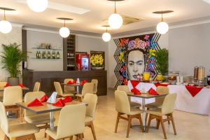 a restaurant with tables and chairs and a bar at Hotel Vizcaya Plaza in Barrancabermeja +10 photos