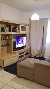 a bedroom with a bed and a tv in a room at Quarto em Apartamento Centro in Criciúma