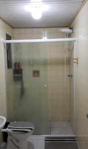 y baño con ducha, aseo y lavamanos. en Quarto em Apartamento Centro en Criciúma