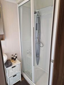 a shower with a glass door in a bathroom at Craig Tara Glen Haven Caravan Dunure Village in Ayr