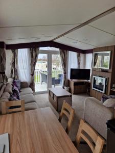 a living room with a couch and a table at Craig Tara Glen Haven Caravan Dunure Village in Ayr