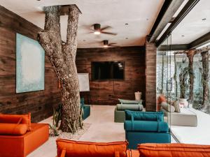 a living room with a tree in the center at Kaaba Luum Jungle Villas in Chemuyil