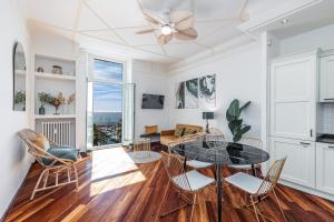 a living room with a table and chairs at PALAIS DE MENTON - Elegant apartment with sea view in Menton