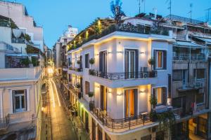 a city street at night with white buildings at Kimon Hotel Athens in Athens