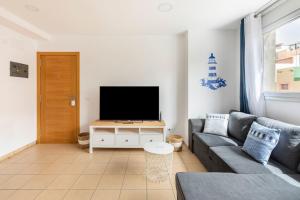 un soggiorno con divano e TV a schermo piatto di La casita de Sardina a Sardina