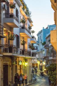 a group of people walking down a street with buildings at Kimon Hotel Athens in Athens