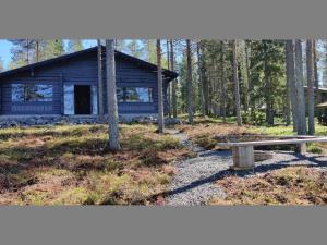 einem Blockhaus mit einer Bank davor in der Unterkunft Holiday Home Kiviniemi by Interhome in Siikakämä