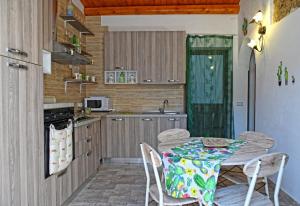 a kitchen with a table and chairs in a kitchen at Ficu Pala Holiday Home in Noto