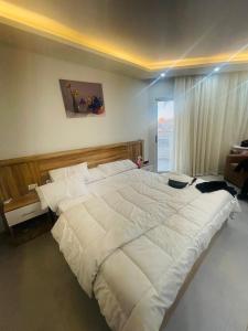uma grande cama branca num quarto com uma janela em The Comfortable palace em Hurghada