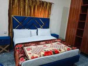 a bedroom with a bed with a quilt on it at Hotel Air inn in Lahore +16 photos