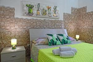 a bedroom with a green bed with two pillows on it at Ficu Pala Holiday Home in Noto