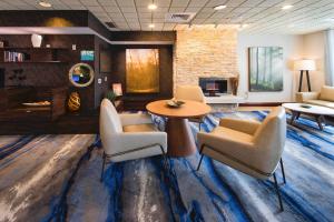 a lobby with chairs and a table and a tv at Fairfield Inn & Suites by Marriott Valdosta in Valdosta
