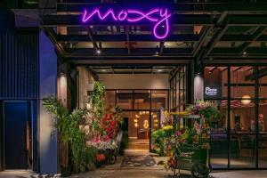 a flower shop with a neon sign on the wall at Moxy NYC Chelsea in New York