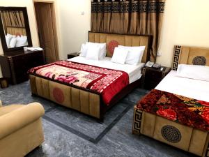 a hotel room with two beds and a couch at Hotel Air inn in Lahore