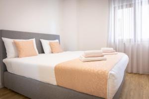 a bedroom with a large bed with two towels on it at Apartments Portun Top Center in Baška Voda