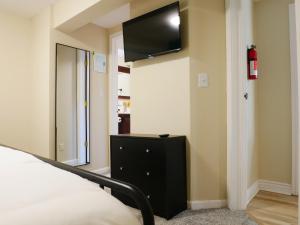 Private Basement, Bath, Living Area In Morrison في موريسون: غرفة نوم مع سرير وتلفزيون على الحائط