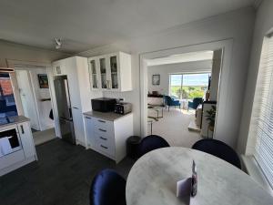 a kitchen and living room with a table and chairs at Art Deco Beauty on The Bay Hill in Timaru