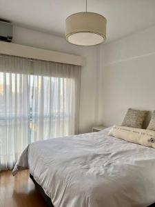 1 dormitorio con cama blanca y ventana grande en Palermo bulnes homes en Buenos Aires