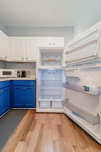 a kitchen with blue cabinets and an empty refrigerator at Comfortable King Suite Zen Space in Hattiesburg