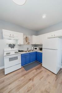 a kitchen with white appliances and blue cabinets at Comfortable King Suite Zen Space in Hattiesburg