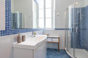 a white bathroom with a sink and a shower at PALAIS DE MENTON - Elegant apartment with sea view in Menton +18 photos