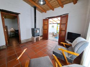 sala de estar con sofá, TV y chimenea en Casa en Tilcara con hermosa galería en Tilcara