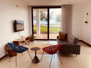 a living room with a couch and chairs and a tv at Villa Luasah in Vila Praia Do Bilene