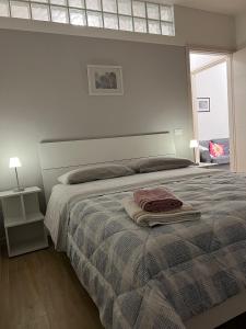 a bedroom with a bed with a blanket and a window at Appartamento con due camere da letto e free park in Verona