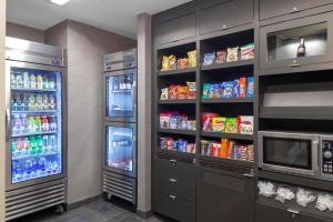 a kitchen with two refrigerators with food and drinks at Courtyard by Marriott St. Louis West County in Saint Louis