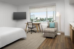 ein Hotelzimmer mit einem Bett, einem Schreibtisch und einem Stuhl in der Unterkunft Element Jacksonville Beach in Jacksonville Beach