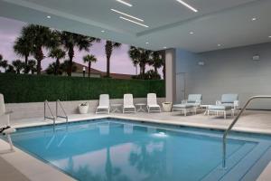 a pool in a hotel with chairs at Element Jacksonville Beach in Jacksonville Beach