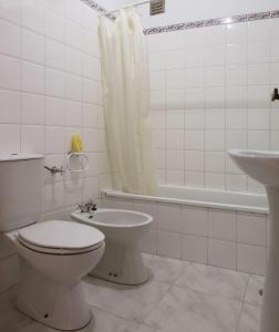 Baño blanco con aseo y lavamanos en Casa da Avó, en Vila Nova de Milfontes