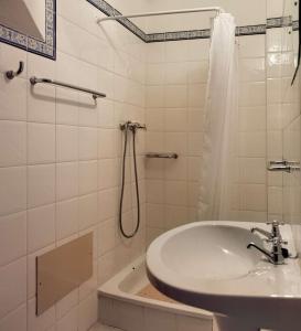 a white bathroom with a sink and a shower at Casa da Avó in Vila Nova de Milfontes +7 photos