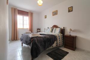 1 dormitorio con 1 cama, vestidor y ventana en Casa da Avó, en Vila Nova de Milfontes