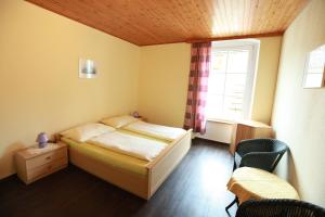 a bedroom with a bed and a window and chairs at Pension Stadt Grein in Grein