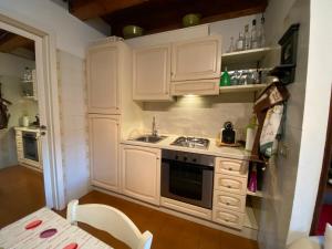 a kitchen with white cabinets and a sink and a table at Casa Vista lago - 24h Check in - Free WiFi - Netflix in Monte Isola