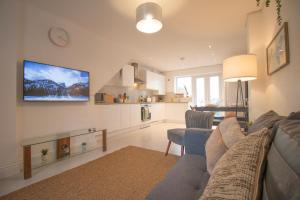 a living room with a couch and a tv on the wall at St Peters Townhouse by Property Promise in Cardiff