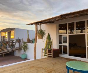 a house with a deck with a table and chairs at Surf HouseMaroc in Essaouira