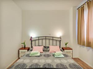 a bedroom with a large bed with pink pillows at Apartment Katja in Rogoznica