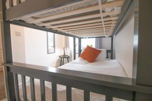 a loft bed with an orange pillow on a balcony at St Peters Townhouse by Property Promise in Cardiff