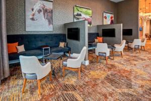 a waiting room with chairs and a couch and tables at Residence Inn by Marriott Kansas City Downtown/Convention Center in Kansas City