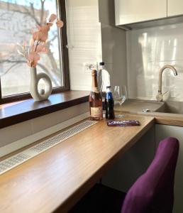 a kitchen counter with two bottles of wine and a window at One Room Iasi in Iaşi