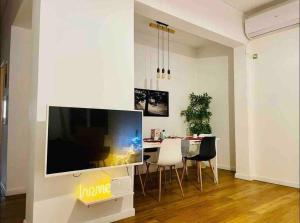 sala de estar con TV grande y mesa de comedor en Vasilis luxury apartment en Athens