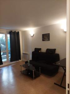 a living room with a couch and a table at ROSNY15 in Rosny-sous-Bois