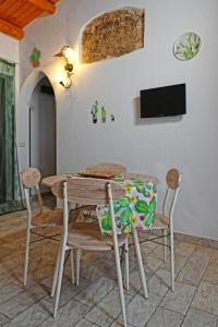 a dining room with a wooden table and chairs at Ficu Pala Holiday Home in Noto